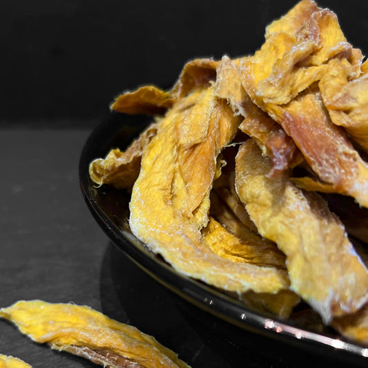 Gedroogde mango in een stijlvolle zwarte kom van Mijn winkel, ideaal als gezonde snack.