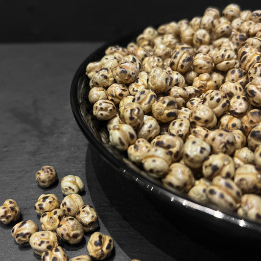 Dubbel Geroosterd Kikkererwten in een zwart bord, een gezonde en eiwitrijke snack van Mijn winkel, perfect voor tussendoor of als topping.