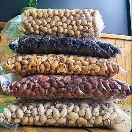 Stapels luxe noten en gedroogd fruit in doorzichtige verpakkingen van Mijn winkel - Golden Pakket.