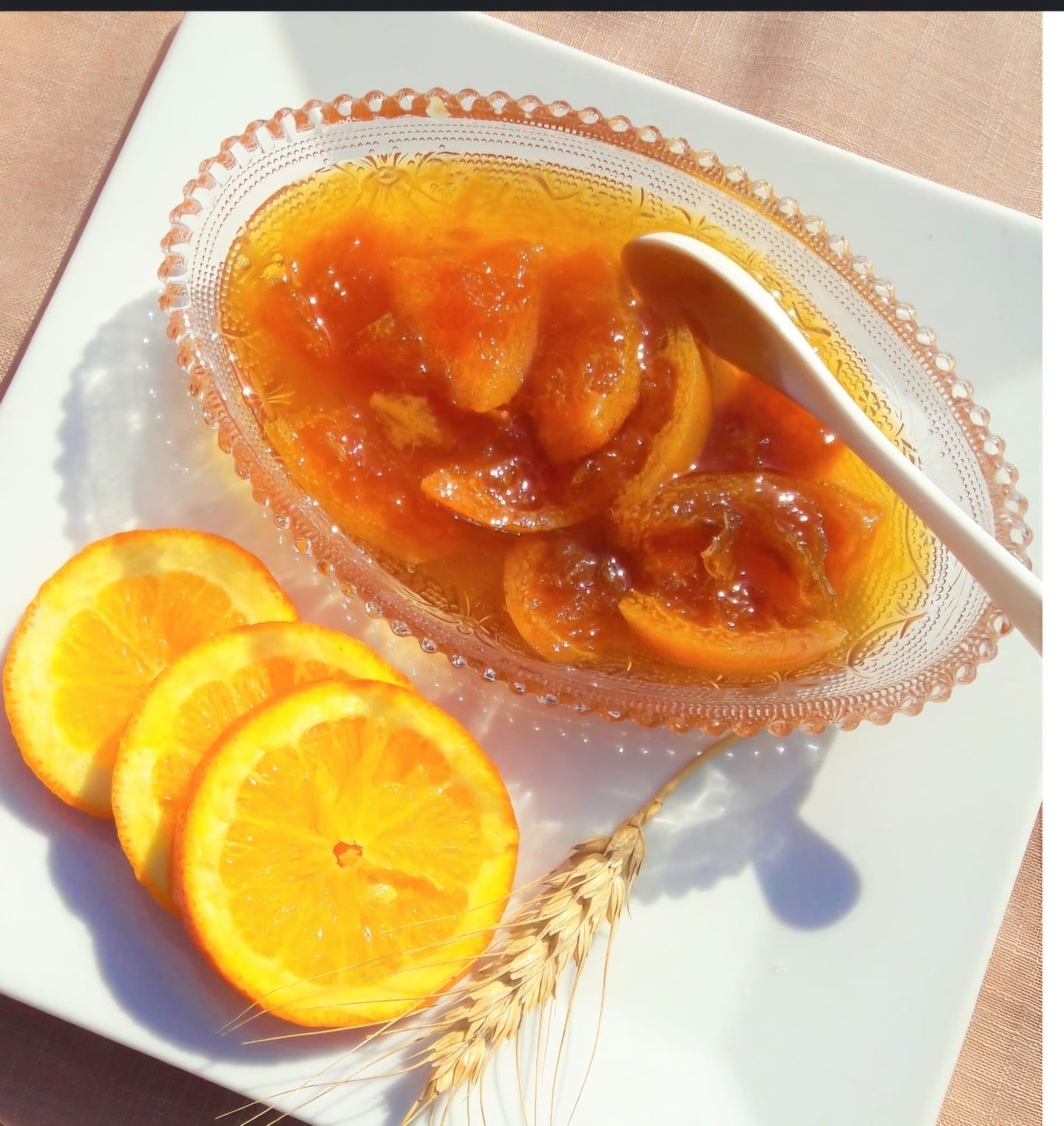 Sinaasappeljam met hele stukken Sinas van Mijn winkel, geserveerd in een elegante schaal, vergezeld van frisse sinaasappelschijfjes.