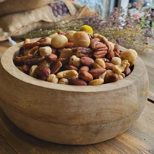 Een houten kom gevuld met een mix van noten, inclusief pecannoten, hazelnoten en andere gezouten noten van Mijn winkel - Notenmix Gebrand Ongezouten.