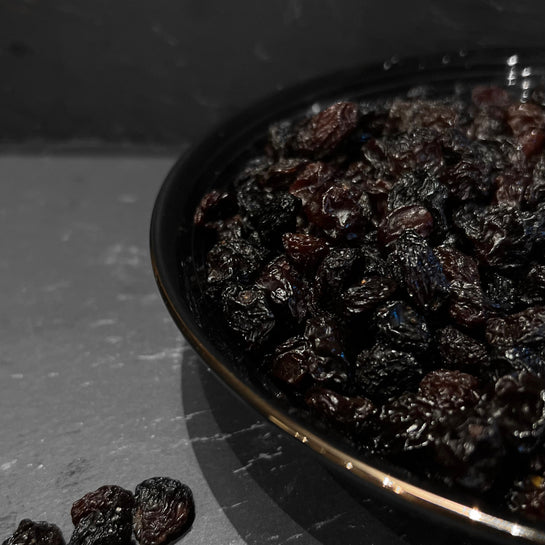 Een kom met sappige zwarte rozijnen van Mijn winkel, perfect als gezonde snack voor iedereen. Van de Rozijnen Zwart, ideaal voor yoghurt, muesli, en meer.