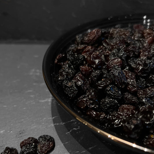 Een kom met sappige zwarte rozijnen van Mijn winkel, perfect als gezonde snack voor iedereen. Van de Rozijnen Zwart, ideaal voor yoghurt, muesli, en meer.