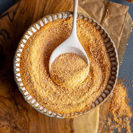 Gedroogde soepmix voor Tarhana (Tarwesoep) van Mijn winkel, gepresenteerd in een keramisch schaaltje met een houten lepel, perfect voor een authentieke Turkse maaltijd.