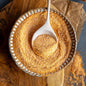 Gedroogde soepmix voor Tarhana (Tarwesoep) van Mijn winkel, gepresenteerd in een keramisch schaaltje met een houten lepel, perfect voor een authentieke Turkse maaltijd.