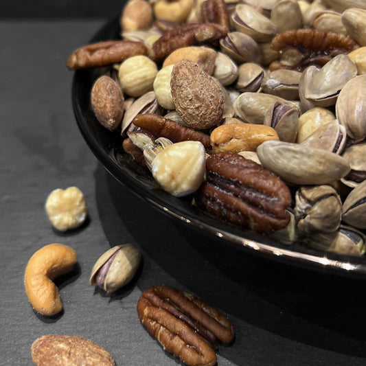 Een heerlijke mix van noten, waaronder pistachenoten, pecannoten en cashewnoten, in een elegante zwarte kom van Mijn winkel. Perfect voor liefhebbers van antepmix gezouten.