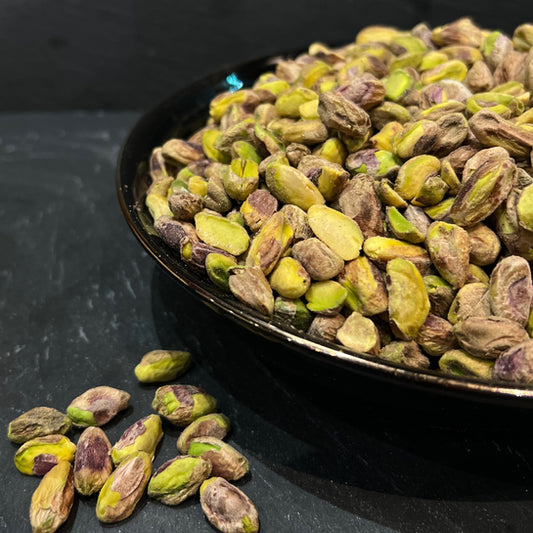 Een schaal vol gepelde pistachenoten van Mijn winkel, met de kenmerkende groene kleur en nootachtige textuur, ideaal voor een smakelijke snack.