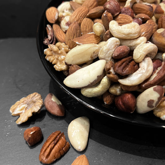 Gezonde notenmix Naturel van Mijn winkel in een zwarte schaal, met ongebrande en ongezouten noten zoals amandelen, walnoten en pecannoten, perfect voor een snack.