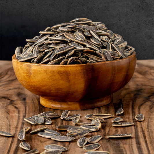 Heerlijke zwart mild gezouten zonnebloempitten in een houten schaal, perfect voor snacks, van Mijn winkel.