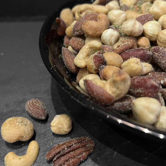 Krokante Provençaalse notenmix in een donkere kom, een heerlijke snack van Mijn winkel, perfect voor een borrel.