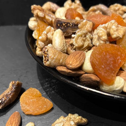 Gezonde vijgenmix van Mijn winkel, bestaande uit noten en gedroogde vijgen in een elegante zwarte schaal, perfect als snack.