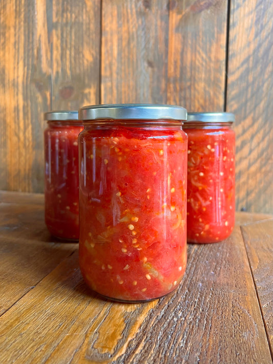 Drie glazen potten Menemenlik Saus van Mijn winkel, gevuld met een pittige tomaten-, peper- en uienmix, ideaal voor het maken van authentiek Turkse gerechten.