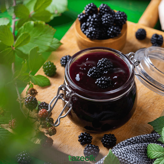 Zwarte Moerbeien Jam 450g van Mijn winkel in een glazen pot, omringd door verse zwarte moerbeien op een houten snijplank.