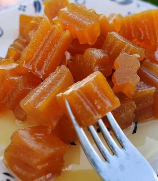 Krokante Pompoen Jam van Mijn winkel, mooi gepresenteerd op een bord, met een vork die een stuk jam optilt.