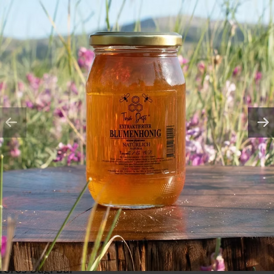 Fles Toros Eğriçayır Bloemenhoning 480G Bio van Mijn winkel, displayed op een houten oppervlak, omringd door groene gras en kleurrijke wilde bloemen.