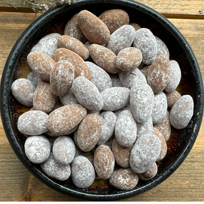 Choco Amandel mix van Mijn winkel, een smakelijke mix van amandelen met een laagje chocolade, gepresenteerd in een zwarte kom.