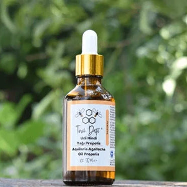 Flesje Propolis Udi Hindi van Mijn winkel, met een pipet en een prachtig groen natuurlijke achtergrond. Dit product combineert puur propolis-extract met Udi Hindi voor ondersteuning van het immuunsysteem.